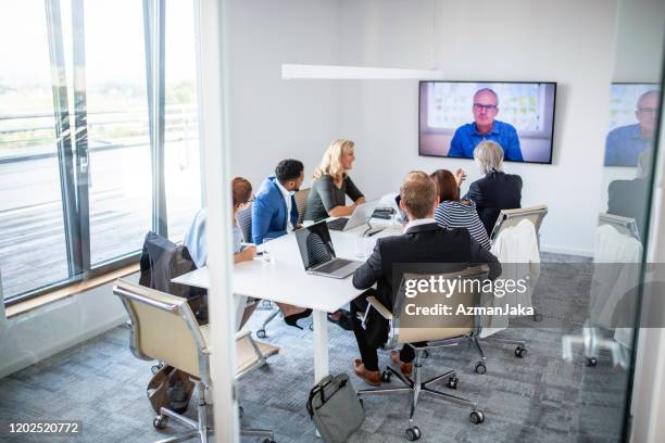 geschäftsleute, die an der videokonferenz teilnehmen - mittlere entfernung stock-fotos und bilder
