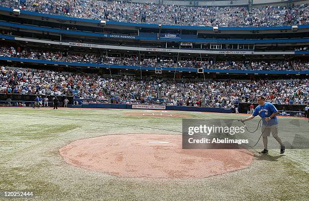 Grounds crew work on the mound as close to 45,000 fans fill the Rogers Centre during MLB action between the Texas Rangers and the Toronto Blue Jays...