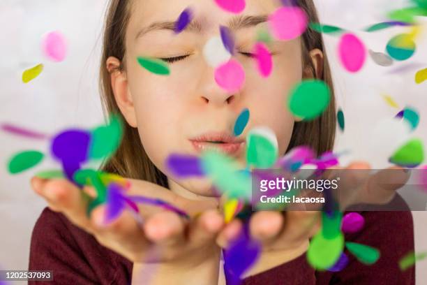 girl blowing confetti - party konfetti stockfoto's en -beelden