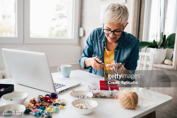 mature woman watching tutorials for making jewelry - craft stock pictures, royalty-free photos & images