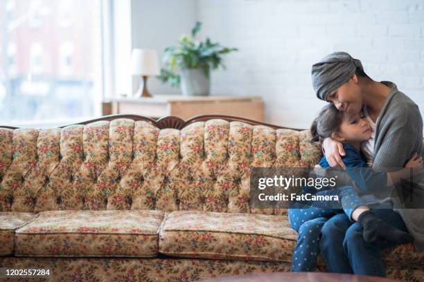 young girl hugging her mother with cancer stock photo - cancer patient with family stock pictures, royalty-free photos & images