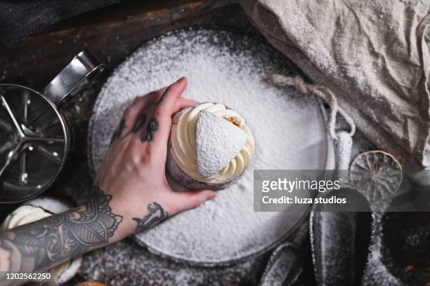woman taking a traditional swedish dessert known as semla - finger bun stock pictures, royalty-free photos & images