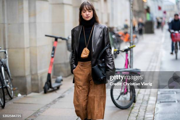 Guest is seen wearing brown velvet cropped pants, black leather jacket, bag around her neck, black bag outside Gestuz on Day 1 during Copenhagen...