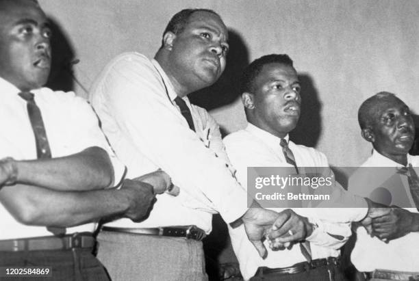 James Farmer and John Lewis join hands and sing after a civil rights meeting. The civil rights leaders spoke to the crowd, termed by one of the...