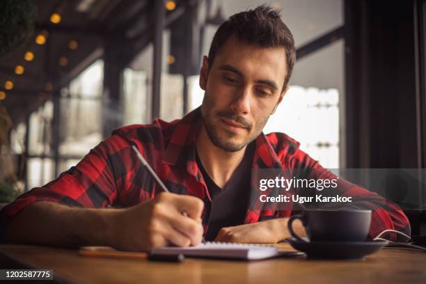young man taking notes. - man writing a letter stock pictures, royalty-free photos & images