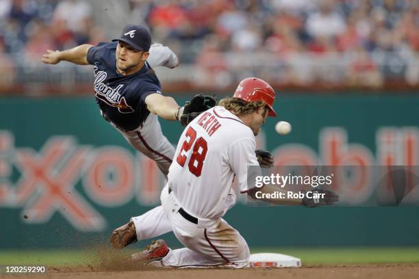 Second baseman Dan Uggla of the Atlanta Braves misses the ball as Jayson Werth of the Washington Nationals steals second base during the second...