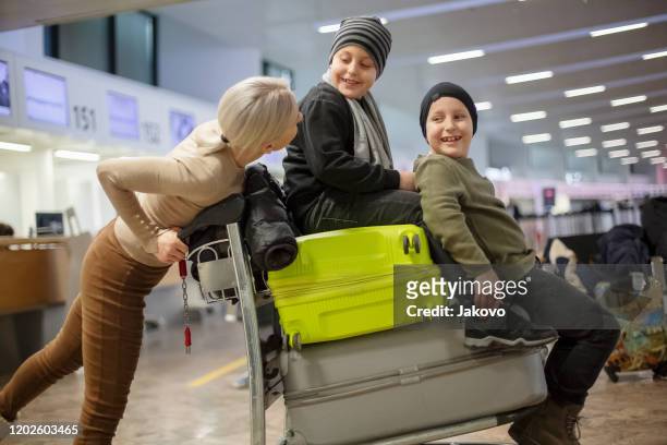 family at the airport traveling and carrying suitcases - cartgate out stock pictures, royalty-free photos & images