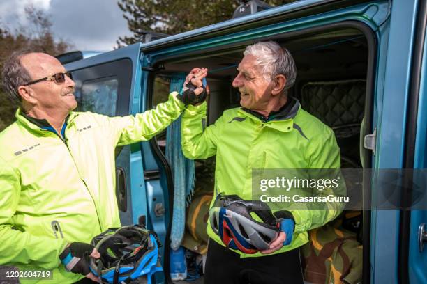 senior adults celebrating successful bicycle training - stock photo - car hi five stock pictures, royalty-free photos & images