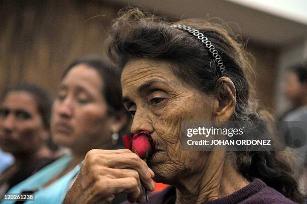 Relative of a victim of the slaugther of the villa Dos Erres holds a rose on August 2, 2011 in Guatemala City during the trial of military men...
