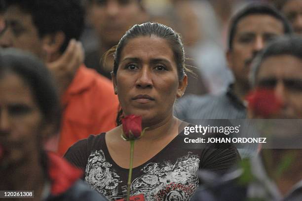 Relative of a victim of the slaugther of the villa Dos Erres holds a rose on August 2, 2011 in Guatemala City during the trial of military men...