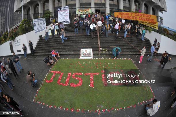 Relatives of the victims of the slaugther of the villa Dos Erres form the word "Justice" with flowers outside the Supreme Court on August 2, 2011 in...