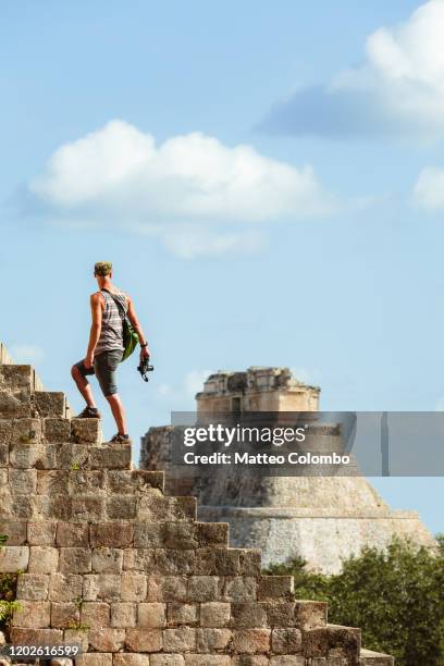 tourist admiring the mayan ruins of uxmal, mexico - uxmal fotografías e imágenes de stock