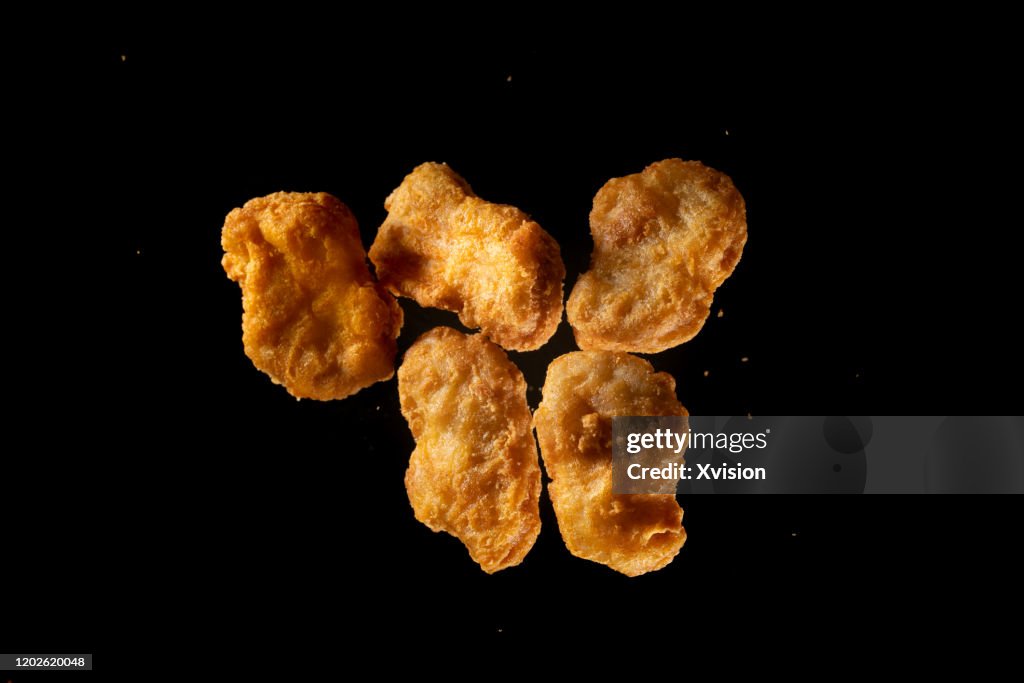 Fried chicken Nuggets flying in mid air view from above
