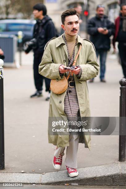 Guest wears a camel turtleneck, a camel and black checkered coat, a black belt, a light brown round canteen bag, a sage green trench coat, light grey...