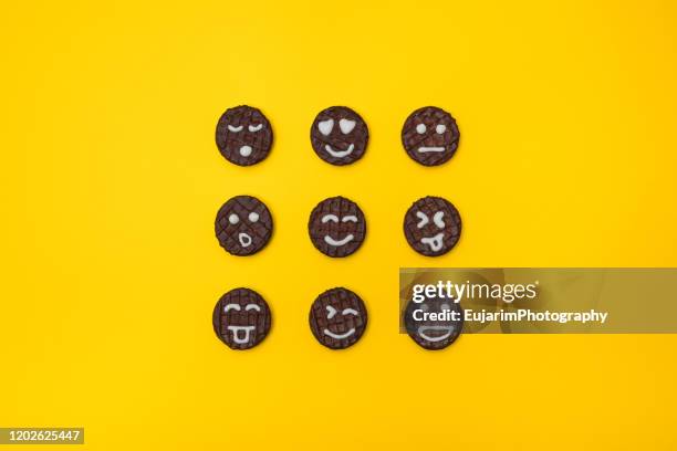 funny face chocolate cookies on yellow background - 感情表現シリーズ ストックフォトと画像