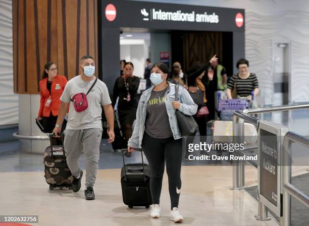 Passengers arriving on flights wear protective masks at the international airport on January 29, 2020 in Auckland, New Zealand. There have been no...