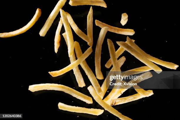 fried potato chips flying in mid air view from above - food mid air stock pictures, royalty-free photos & images