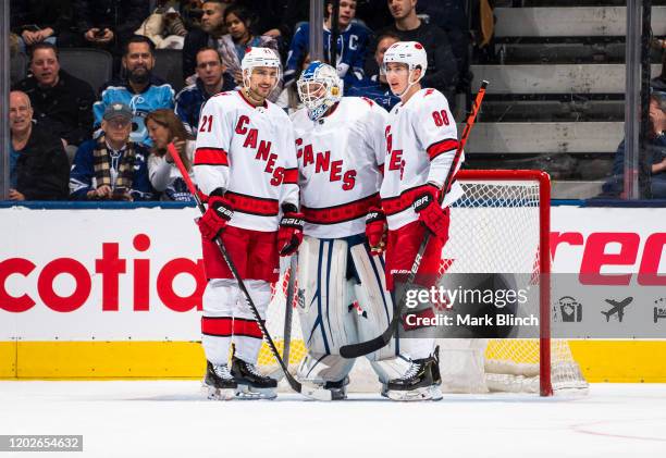 Nino Niederreiter and Martin Necas of the Carolina Hurricanes talk with emergency backup goaltender Dave Ayres during the second period against the...