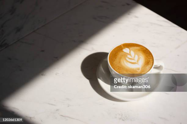 close up cappuccino cup with lighting and copy space - cafe latte stockfoto's en -beelden