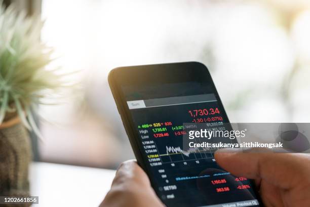 businessman trading stocks with smarthphone and check stock market data - rinviare la palla foto e immagini stock