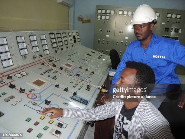 January 2020, Ethiopia, Koka-Wasserkraftwerk: Electrical engineer Sisey Hussein and Voith expert Mulugeta Mitiku work at the control panel of the...