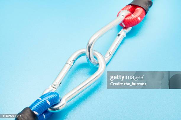 close-up of two carabiners with blue and red rope on blue background - カラビナ ストックフォトと画像