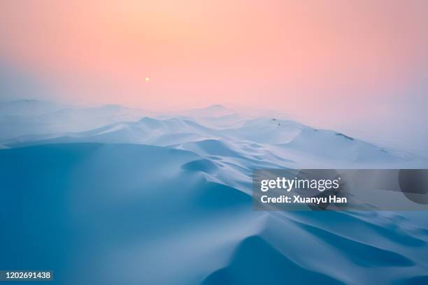 snow covered desert sand dunes at sunset in winter - moutain sunset snow stock-fotos und bilder