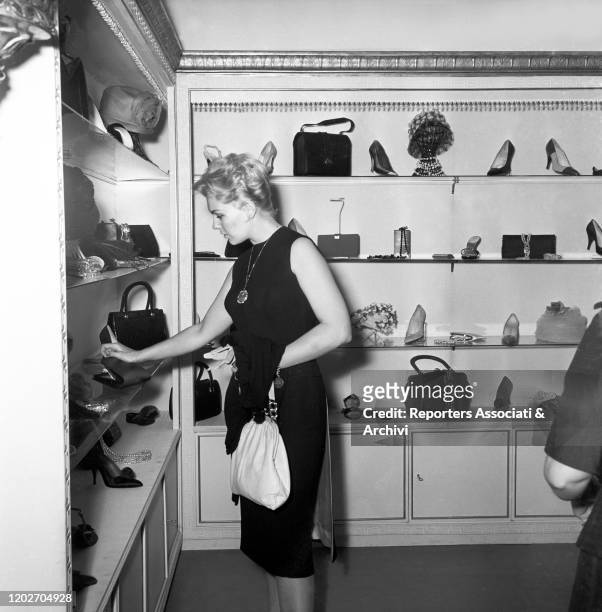 American actress Kim Novak watching some shoes designed by Sorelle Fontana fashion house, established by sisters and Italian fashion designers Zoe,...