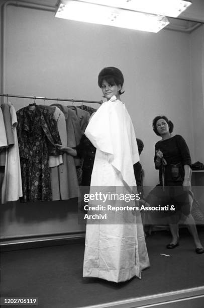 Italian actress Claudia Cardinale trying on a dress at Nina Ricci's fashion house in Paris. Paris, 10th February 1962