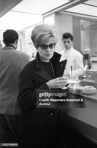 Italian actress Monica Vitti drinking in a bar. Italy, 1960