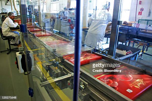 An employee monitors boxes of Lindt chocolate, packaged for Christmas, on the production line inside the Lindt & Spruengli AG factory in Kilchberg,...