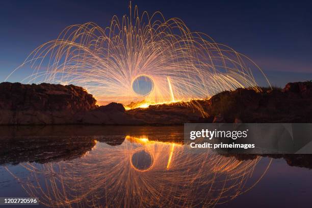 schwingen brennende stahlwolle in abstrakte form - burning steel wool firework stock-fotos und bilder