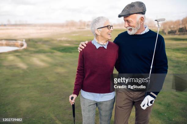 seniorenpaar von golfern genießen ihr spiel - golf stock-fotos und bilder