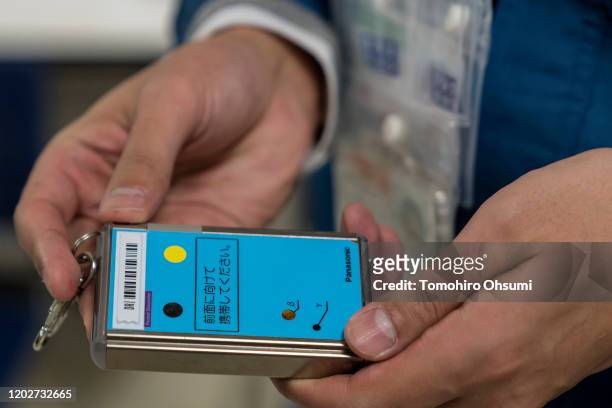 An employee holds a dosimeter at Tokyo Electric Power Co.'s Fukushima Dai-ichi nuclear power plant on January 29, 2020 in Okuma, Fukushima...
