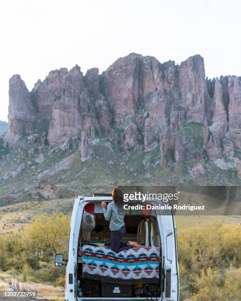 woman in off road vehicle, superstition mountains in background, arizona, united states - superstition mountains fotografías e imágenes de stock