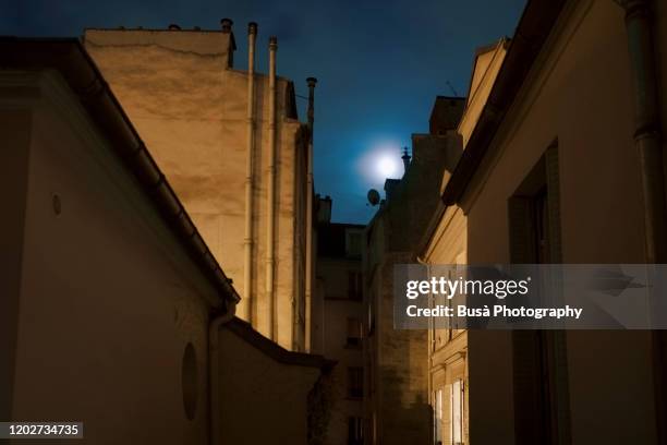 view of rooftops of montmartre at night. paris, france - moody sky moon night stock pictures, royalty-free photos & images