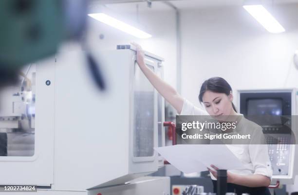 asian woman reading and working in technical office - bata de laboratório - fotografias e filmes do acervo
