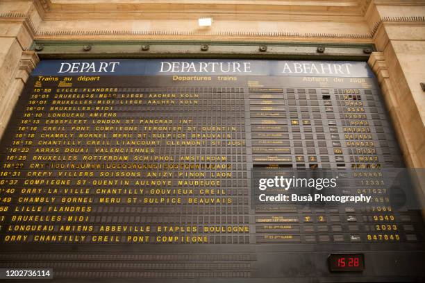 arrivals and departures timetable inside gare de l'est in paris, france - train arrival stock pictures, royalty-free photos & images