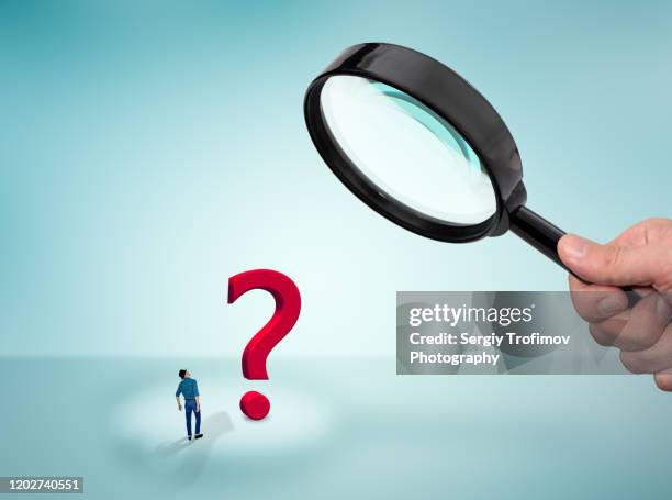 hand holding a magnifying glass and small man looking at question mark - explore icon stock pictures, royalty-free photos & images