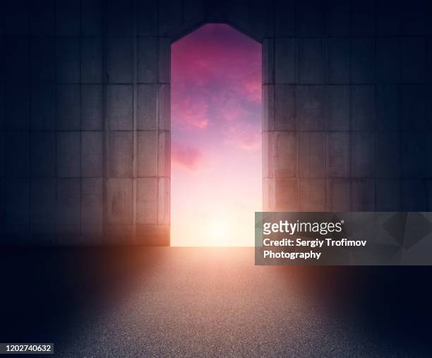 door in concrete wall with sunset sky and light on background - unlocking door stock pictures, royalty-free photos & images