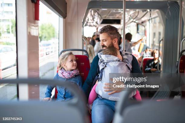 conscious father with daughter and toddler in carrier sitting on bus in city, travelling. - slovakia city stock pictures, royalty-free photos & images