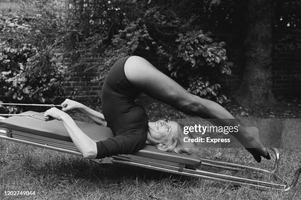 Honor Blackman, dressed in a leotard, exercising on a keep-fit machine, circa 1975.