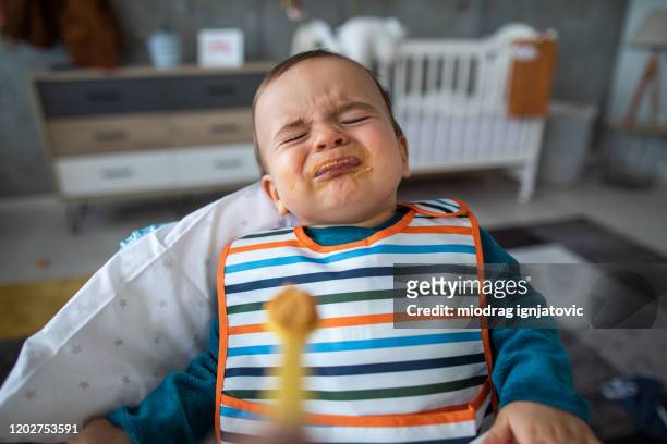 angry toddler not liking solid food - tantrum stock pictures, royalty-free photos & images