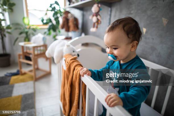 happy boy in the crib - modern baby nursery stock pictures, royalty-free photos & images