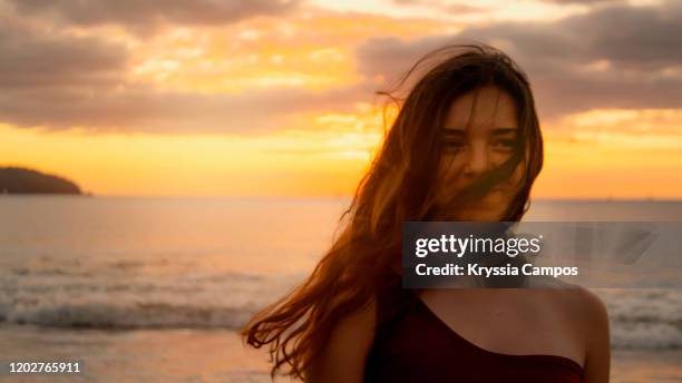 portrait of beautiful young woman at twilight in a tropical beach in costa rica - wavy hair beach stock pictures, royalty-free photos & images