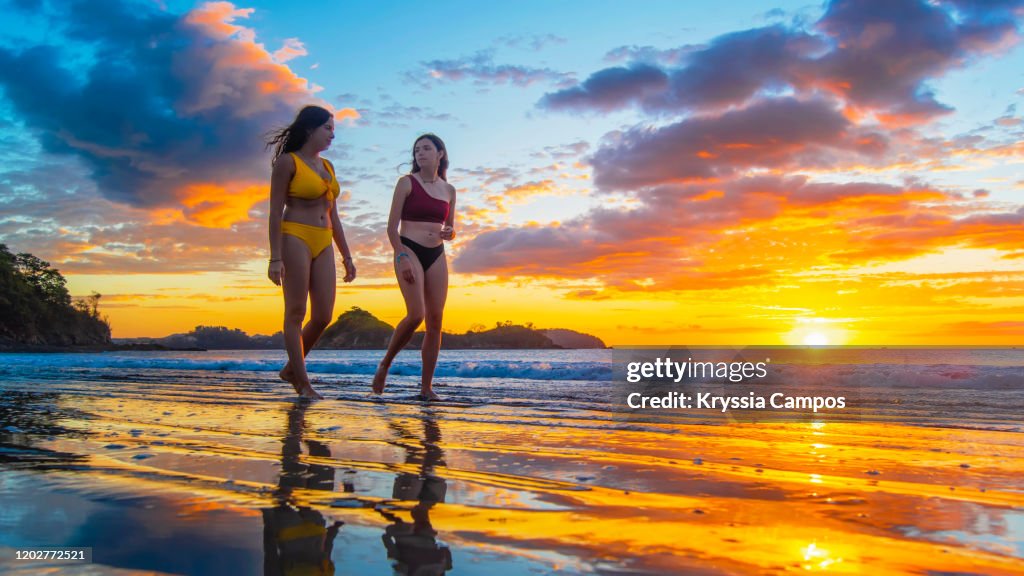 Two of Young Women Walking at Twilight on a Tropical Beach in Costa Rica
