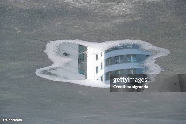 modern building reflected in a puddle - water puddle stock pictures, royalty-free photos & images