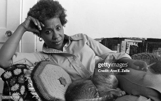 Portrait of American artist and educator Mildred Thompson as she poses with her cat, Asterix, on a couch in her studio, Washington DC, May 30, 1979.