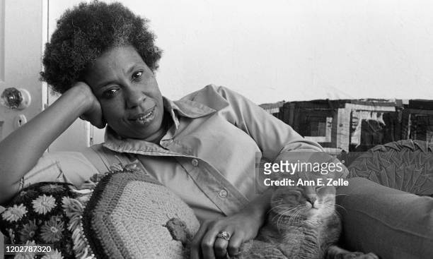 Portrait of American artist and educator Mildred Thompson as she poses with her cat, Asterix, on a couch in her studio, Washington DC, May 30, 1979.