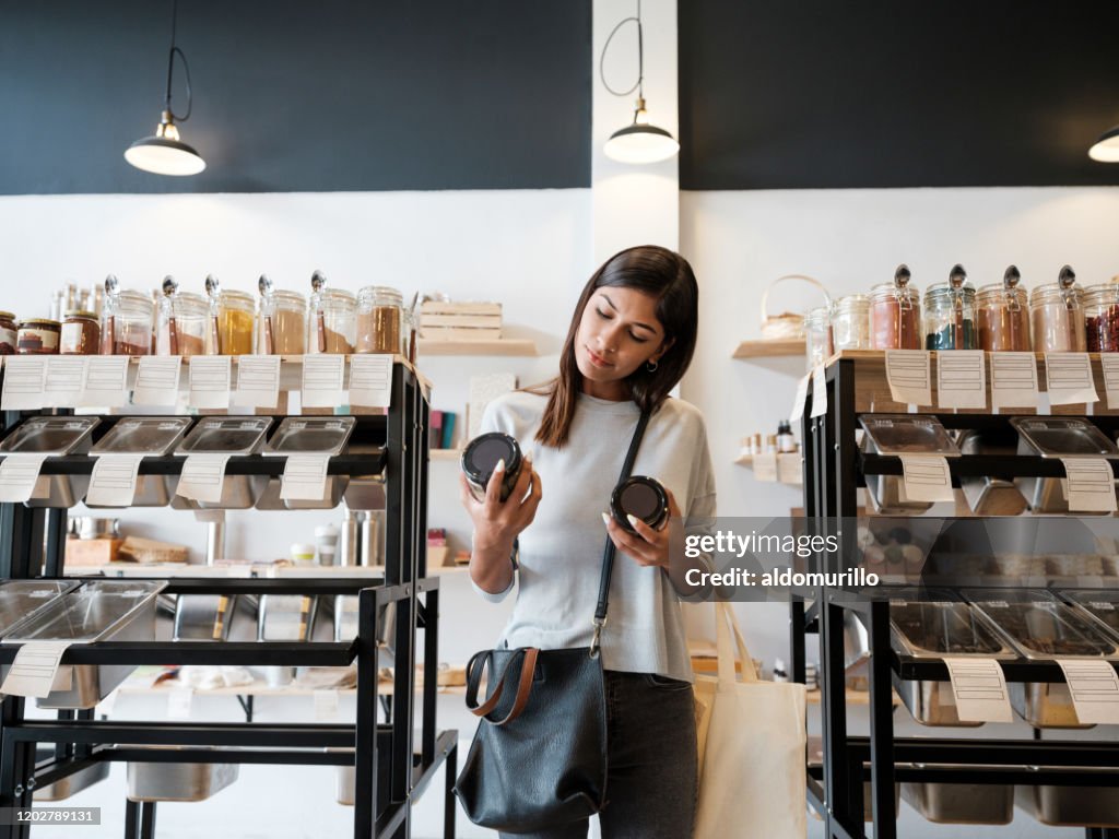 Young woman holding jars in zero waste store